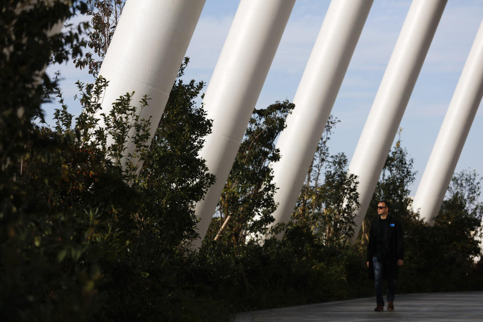 A man walks along a walkway called "Grove of the Sky" at the new National Stadium Sunday, Dec. 15, 2019, in Tokyo. The stadium is officially completed. (AP Photo/Jae C. Hong)