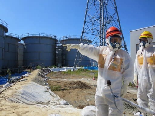 A handout picture taken by Tokyo Electric Power Co. (TEPCO) on August 26, 2013 shows Japanese ministers inspecting contamination water tanks at the Fukushima nuclear power plant. The leaking of toxic water from the stricken plant will not affect Tokyo, the head of capital's 2020 Olympic Games bid Tsunekazu Takeda told AFP