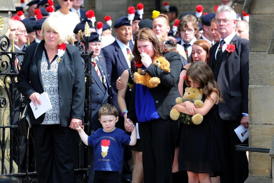 The family of Fusilier Rigby; wife Rebecca (centre) with son Jack, mum Lyn (2nd right) and stepfather (right) Ian follow his coffin as it leaves Bury Parish church in Bury, Greater Manchester (PA)