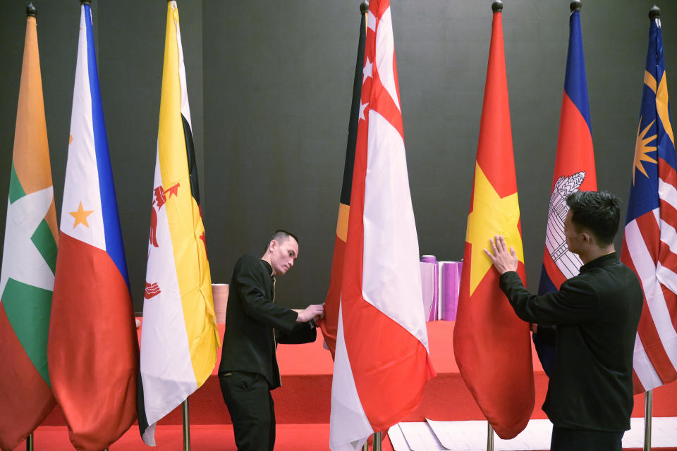 Indonesian workers prepare flags of the member countries of the Association of Southeast Asian Nations (ASEAN) in Jakarta, Indonesia, Monday, July 10, 2023. Myanmar's prolonged civil strife, tensions in the disputed South China Sea and concern over arms buildups in the region are expected to dominate the agenda when Southeast Asia's top diplomats gather for talks this week in Indonesia. (AP Photo/Achmad Ibrahim)