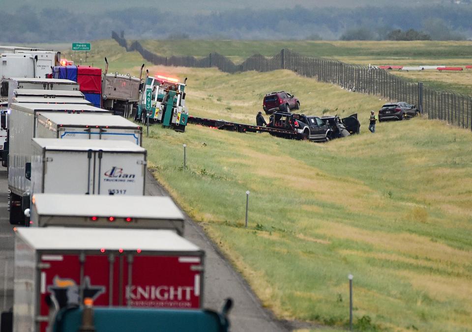 First responders work the scene on Interstate 90 after a fatal pileup where at least 20 vehicles crashed near Hardin, Mont., Friday, July 15, 2022.