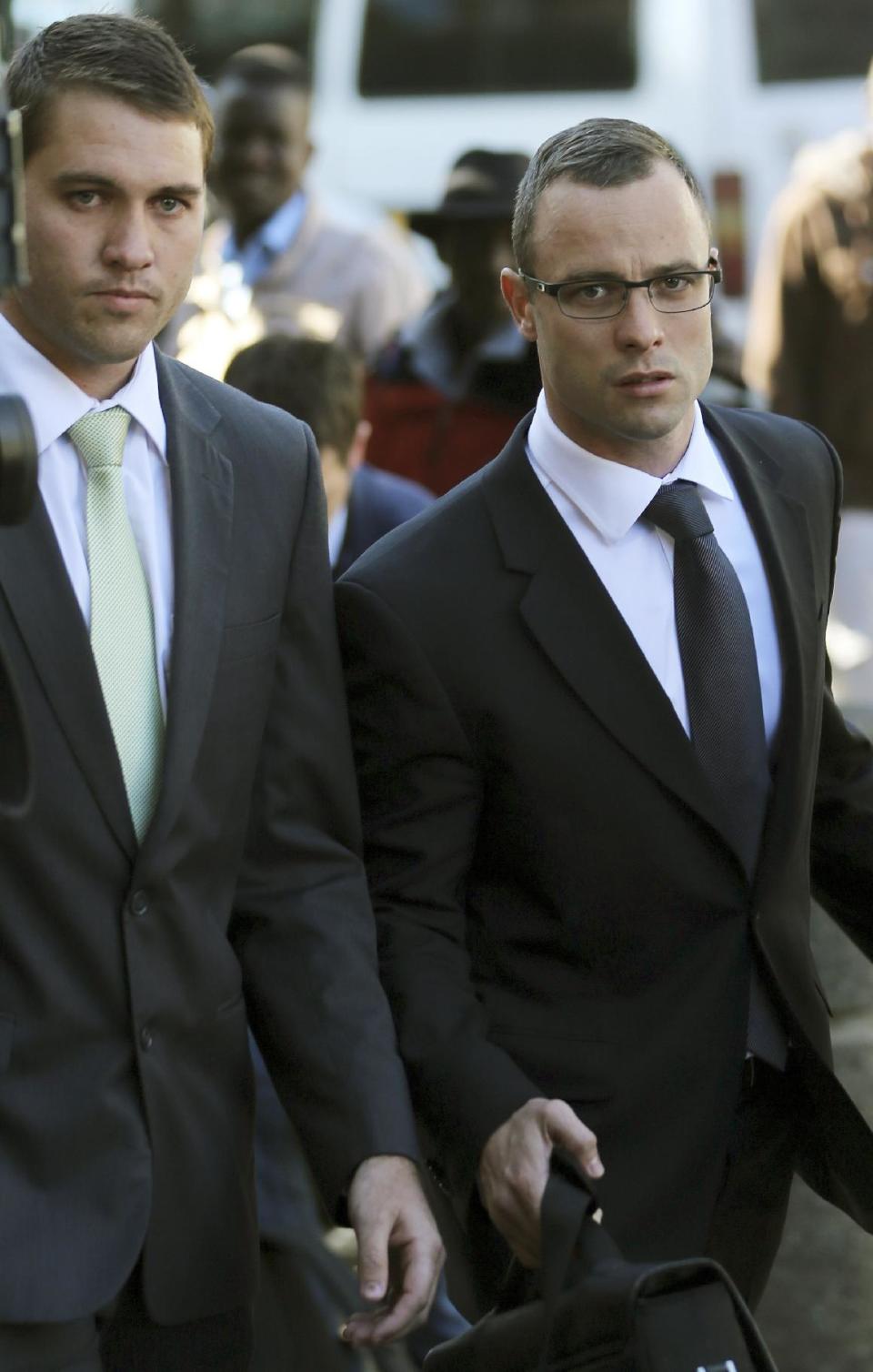 Oscar Pistorius, right, accompanied by an unidentified relative walks towards the high court in Pretoria, South Africa, Wednesday, May 14, 2014. Pistorius is charged with murder for the shooting death of his girlfriend Reeva Steenkamp on Valentine's Day in 2013. (AP Photo/Themba Hadebe)