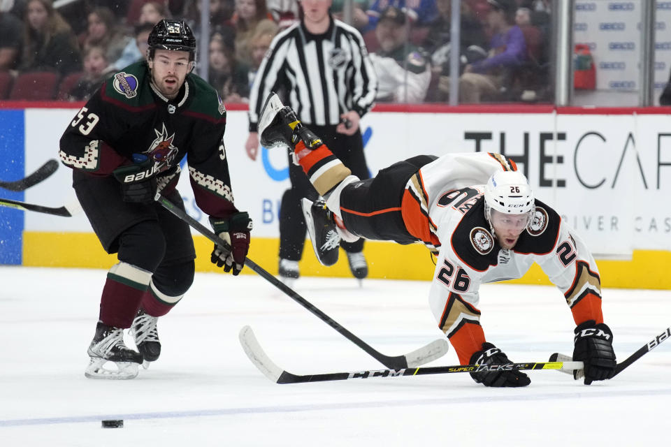 Anaheim Ducks center Gerry Mayhew (26) get sent to the ice by Arizona Coyotes left wing Michael Carcone during the first period of an NHL hockey game Friday, April 1, 2022, in Glendale, Ariz. (AP Photo/Rick Scuteri)