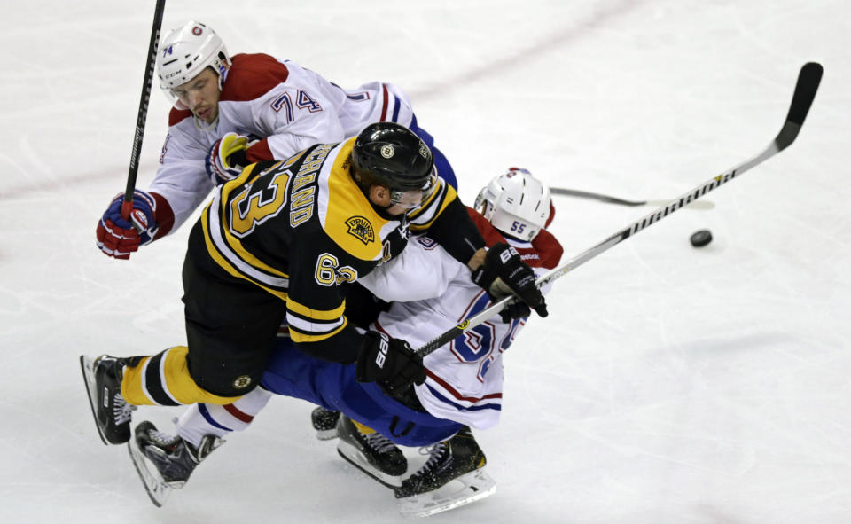 Boston Bruins left wing Brad Marchand (63) tries to thread between Montreal Canadiens defensemen Francis Bouillon (55) and Alexei Emelin (74) during the third period of Game 1 in the second-round of the Stanley Cup playoff series in Boston, Thursday, May 1, 2014. (AP Photo/Charles Krupa)