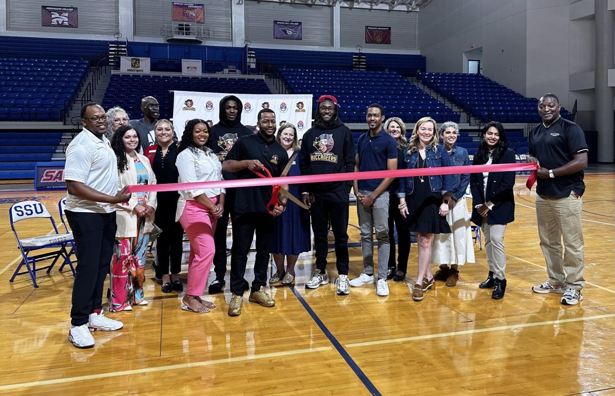 Prescott Mack, the Managing Partner of the Coastal Georgia Buccaneers, cuts a ribbon signifying the start of the season at a press conference Thursday.