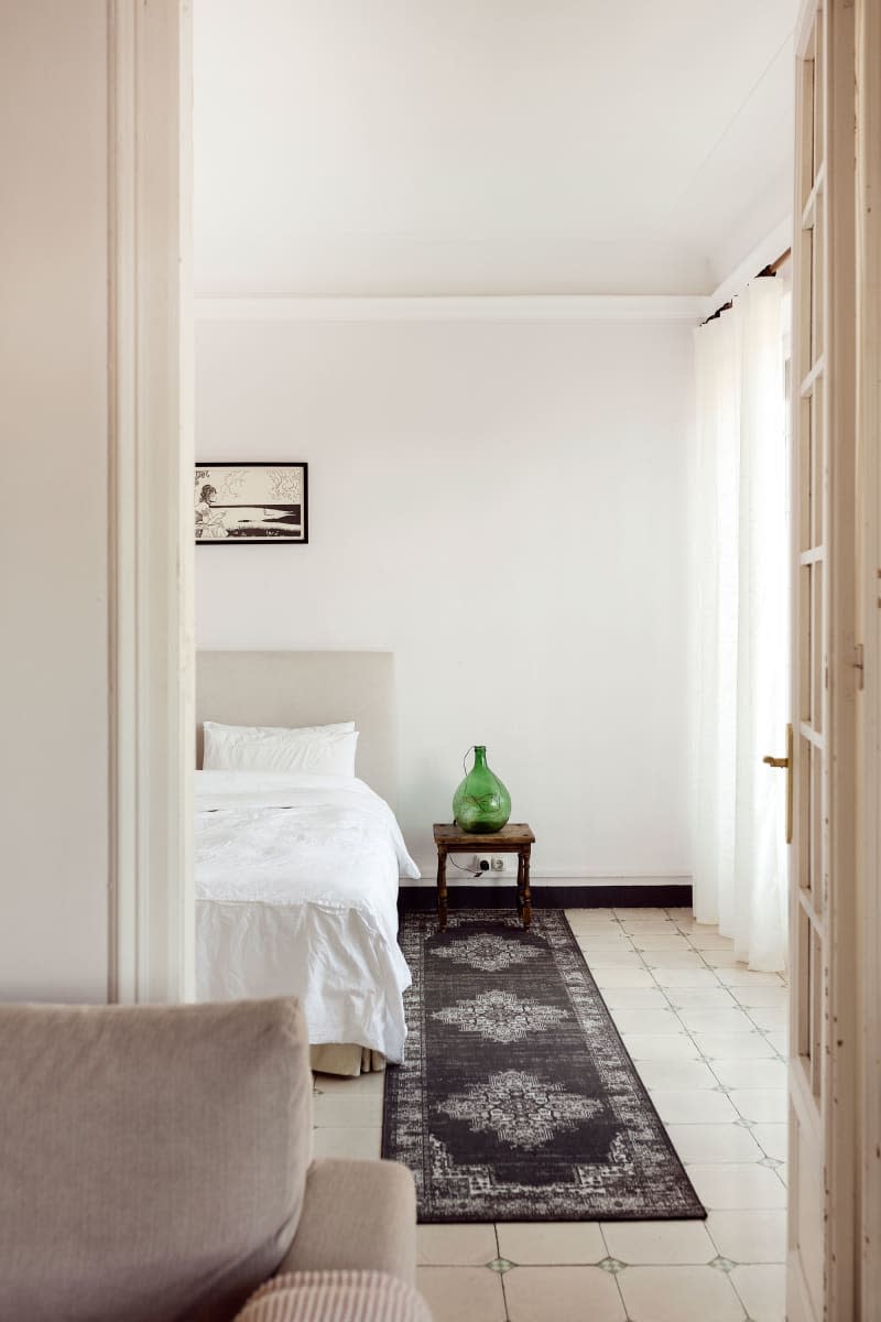 Runner is seen alongside bed in neutral toned living room.