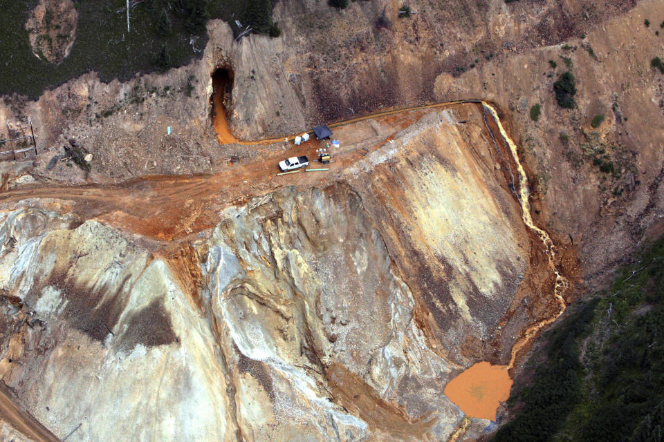 FILE - In this Aug. 11, 2015, aerial photo, wastewater streams out of the Gold King Mine in southwestern Colorado after a contractor crew hired by the Environmental Protection Agency inadvertently triggered the release of about 3 million gallons of water tainted with heavy metals. The Navajo Nation's Department of Justice announced on Wednesday, Jan. 13, 2021, it has settled with two mining companies to resolve claims stemming from the 2015 spill that sent wastewater downstream from the inactive Gold King Mine in southwestern Colorado. (Geoff Liesik/The Deseret News via AP, File)