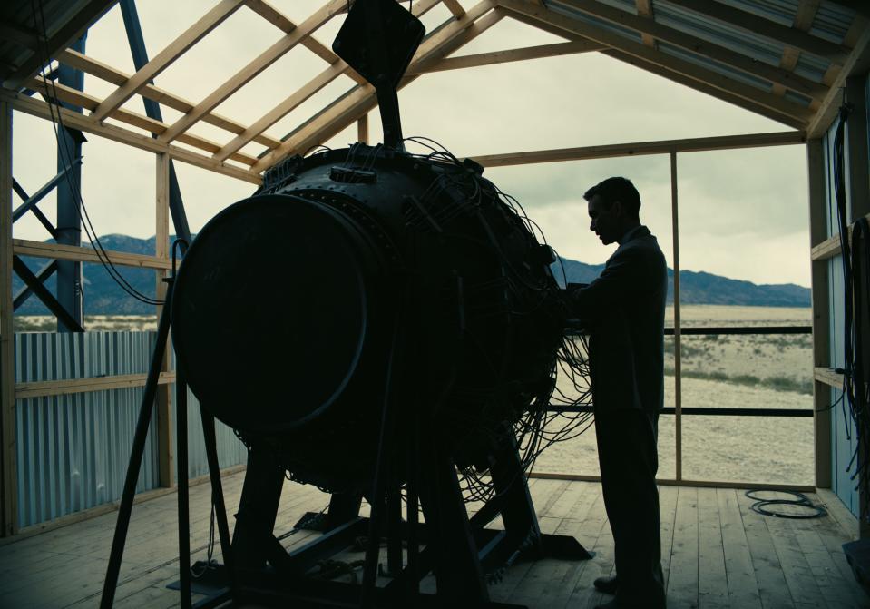 Cillian Murphy standing next to atomic bomb