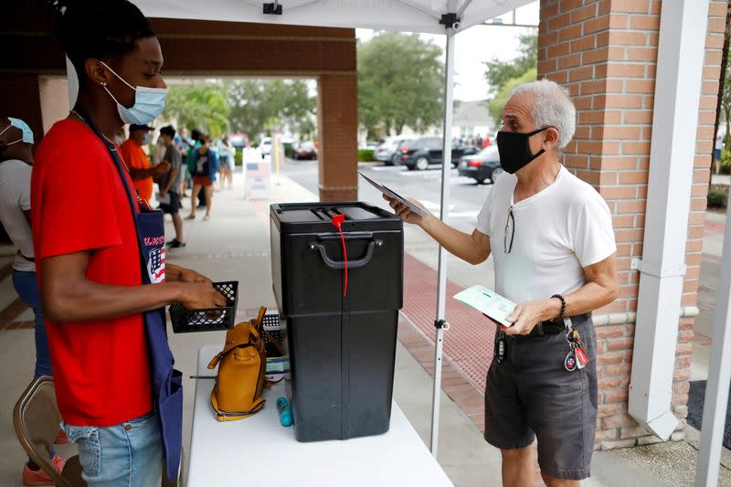 People line up at a polling station as early voting begins in Florida