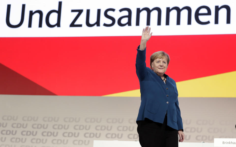 German Chancellor and chairwoman of the German Christian Democratic Union (CDU), Angela Merkel, waves after her farewell speech during a party convention of the CDU in Hamburg, Germany, Friday, Dec. 7, 2018. 1001 delegates are electing a successor of German Chancellor Angela Merkel who doesn't run for party chairmanship after more than 18 years at the helm of the party. Slogan reads 'And Together'. ( AP Photo/Michael Sohn)