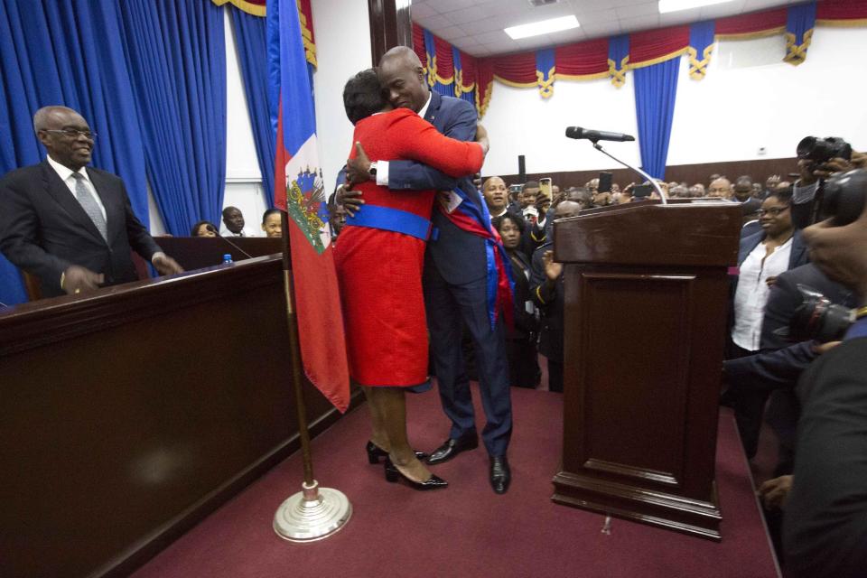 Haiti's President Jovenel Moise hugs his wife Martine after being sworn-in at Parliament in Port-au-Prince, Haiti, Tuesday Feb. 7, 2017. Moise was sworn as president for the next five years after a bruising two-year election cycle, inheriting a struggling economy and a deeply divided society. (AP Photo/Dieu Nalio Chery)