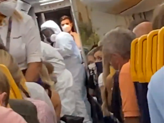 Still image taken from video of officials in hazmat suits removing two passengers from a Ryanair flight at Stansted Airport after one of them tested positive for coronavirus. (Screengrab/Twitter/@FionnMurphy10)
