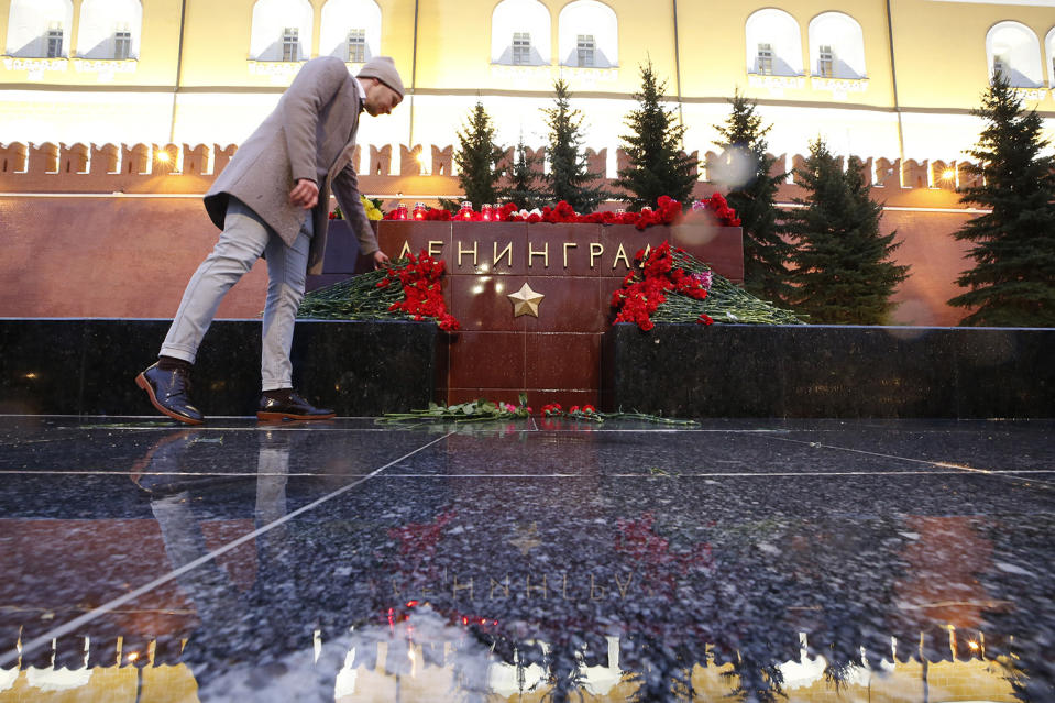 Man lays flowers during memorial service for victims