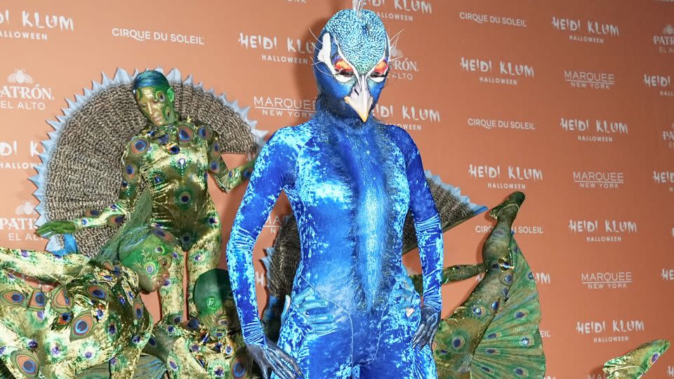Queen of Halloween, Heidi Klum, came dressed as a peacock — her costume was completed by a team of acrobats dressed as her plume of feathers. - John Nacion/WWD/Getty Images