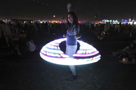 A concert-goer dances using an illuminated hula hoop during the Coachella Music Festival in Indio, California in this April 12, 2013 file photo. REUTERS/Mario Anzuoni/Files
