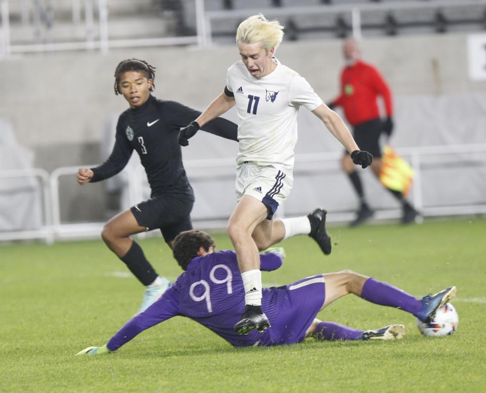 Ottawa Hills' Evan West and Julian Jaume fight Grandview's Danny Claypool for the ball during the Division III state final at Lower.com Field on Nov. 12. Grandview won 3-0.