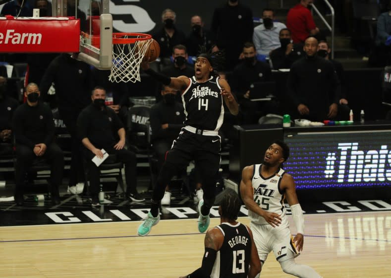 LOS ANGELES, CA - JUNE 18, 2021:LA Clippers guard Terance Mann (14) scores on a break away against Utah Jazz guard Donovan Mitchell (45) in the 3rd quarter of game 6 of the second round of the NBA Playoffs at Staples Center on June 18, 2021 in Los Angeles, California.(Gina Ferazzi / Los Angeles Times)