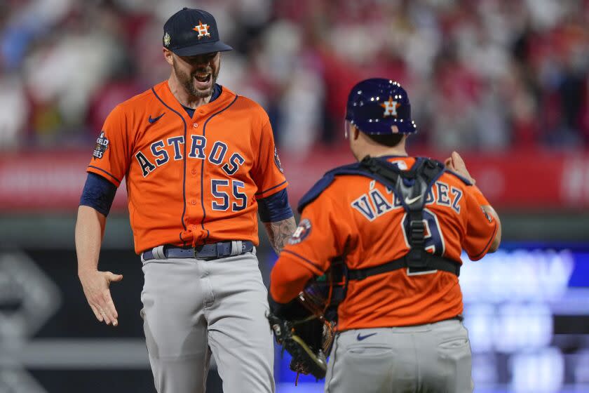 Houston Astros relief pitcher Ryan Pressly and catcher Christian Vazquez celebrate their win in Game 4 of baseball's World Series between the Houston Astros and the Philadelphia Phillies on Wednesday, Nov. 2, 2022, in Philadelphia. The Astros won 5-0 to tie the series two games all. (AP Photo/Matt Slocum)