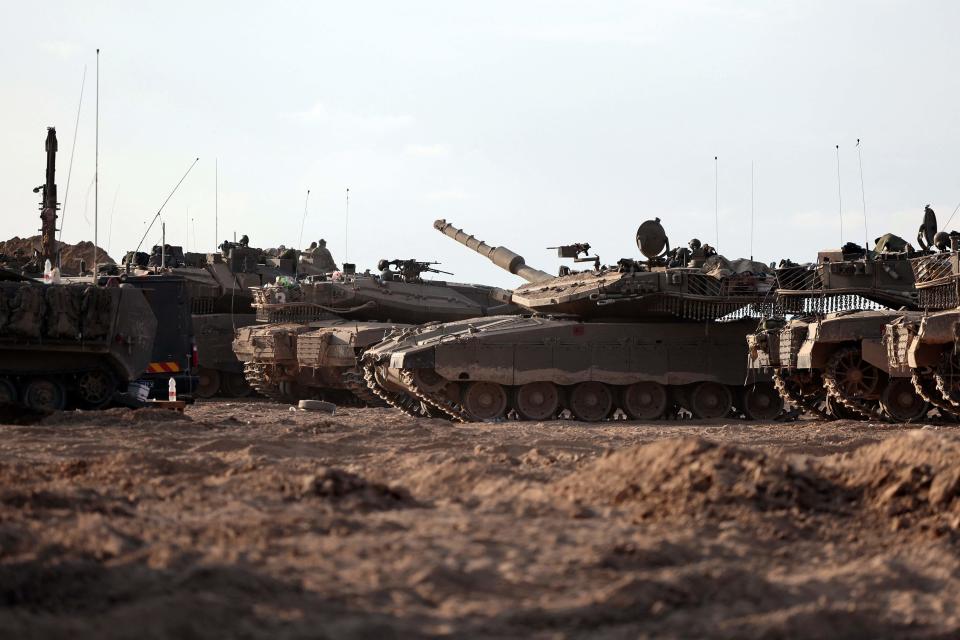 Israeli tanks gather in a field near the kibbutz Beeri in southern Israel on Oct. 14, 2023, close to the spot where more than 350 revelers were gunned down or burnt in their cars by Hamas gunmen at the Supernova music festival in the Negev desert on Oct. 7.
