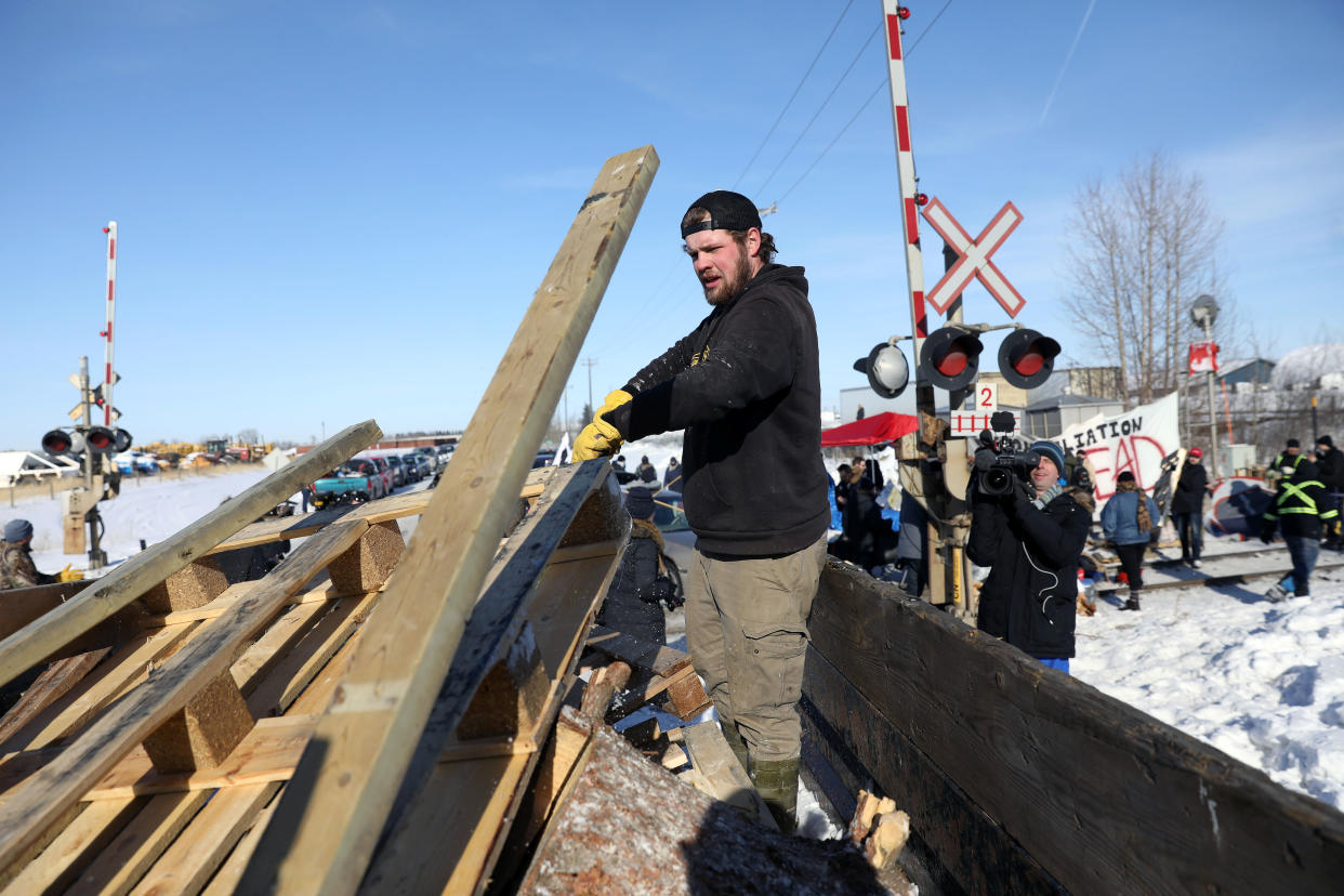 A counter protester removes pieces of the blockade as supporters of the indigenous Wet'suwet'en Nation's hereditary chiefs camp at a railway blockade as part of protests against British Columbia's Coastal GasLink pipeline, in Edmonton, Alberta, Canada February 19, 2020.  REUTERS/Codie McLachlan