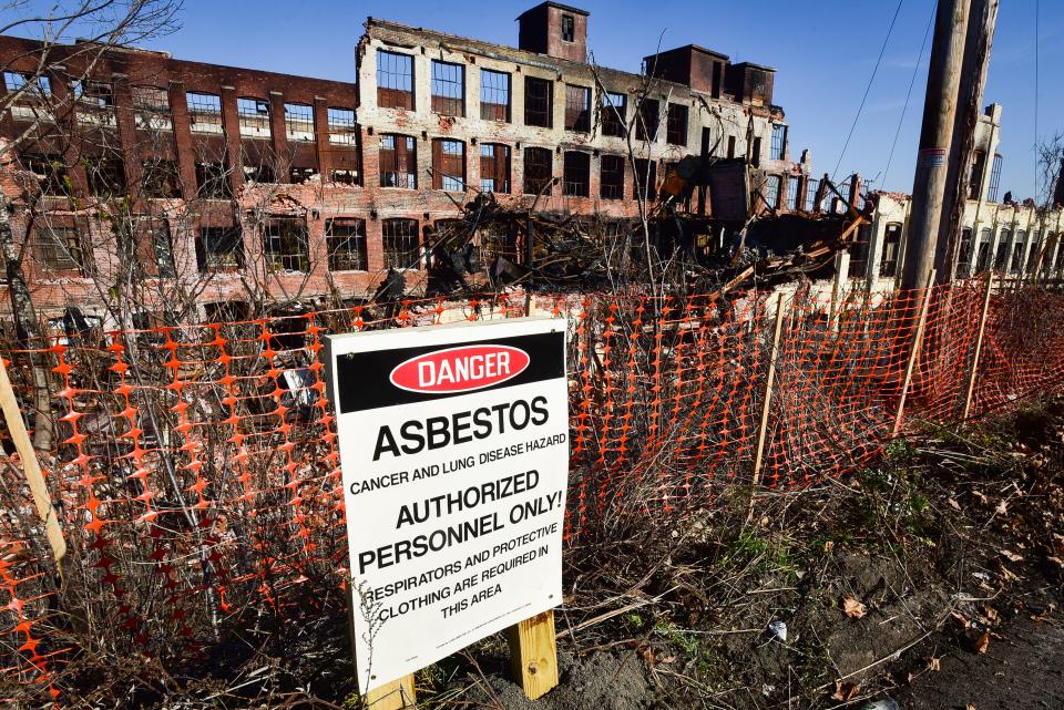 An asbestos sign is displayed near the ruins of the CharlesTown Mall site on Friday, Nov. 6, 2020.