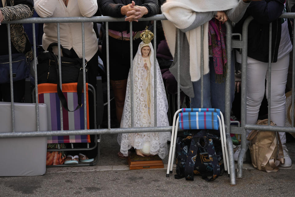 Fieles, junto a una imagen de la Virgen de Fátima, esperan la llegada del papa Francisco al santuario de Fátima, en Fátima, en el centro de Portugal, el 5 de agosto de 2023. (AP Foto/Francisco Seco)