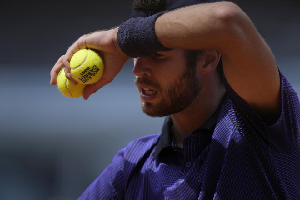 Russia's Karen Khachanov wipes his face as he prepares to serve to Japan's Kei Nishikori during their second round match on day four of the French Open tennis tournament at Roland Garros in Paris, France, Wednesday, June 2, 2021. (AP Photo/Thibault Camus)