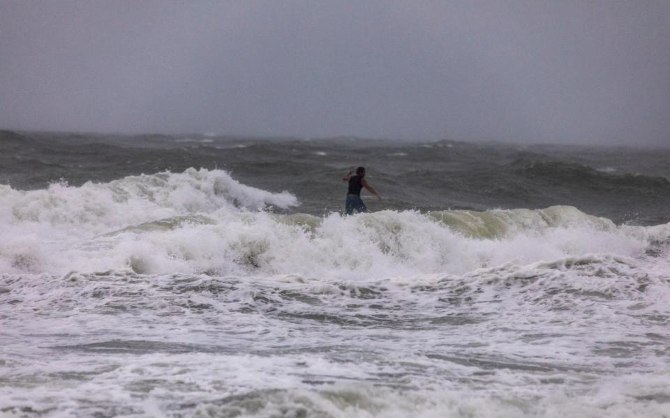 A surfer chances stormy seas off the coast of Garden City, South Carolina before Hurricane Isaias makes landfall - Jason Lee/The Sun News