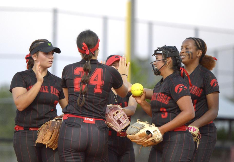 Seminole Ridge's Bella Martinez is handed the ball and encouraged by teammates prior to the start of the third inning on May 9, 2024.