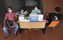 People receive a shot of the Sinovac's COVID-19 vaccine during a vaccination campaign at the Patriot Candrabhaga Stadium in Bekasi on the outskirts of Jakarta, Indonesia Friday, Nov. 26, 2021. Indonesia has significantly recovered from a mid-year spike in coronavirus cases and deaths that was one of the worst in the region, but with its vaccination drive stalling and holidays approaching, experts and officials warn the island nation could be set soon for another surge. (AP Photo/Achmad Ibrahim)