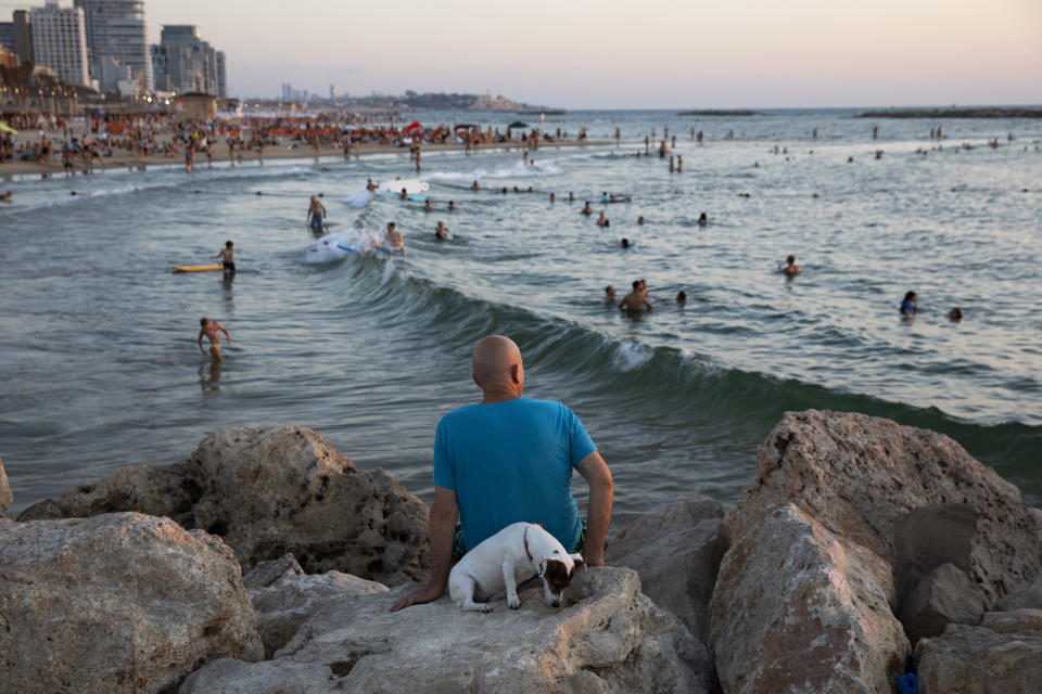 Beachgoers enjoy a summer day on Mediterranean Sea beach of Tel Aviv, Israel, Saturday, Aug. 14, 2021. (AP Photo/Oded Balilty)
