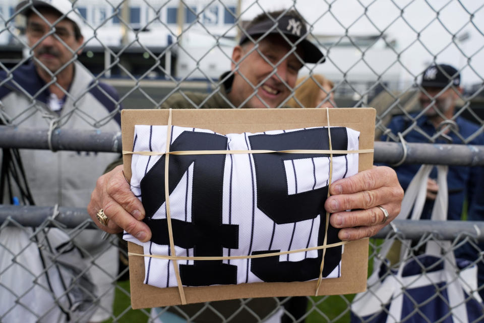 A fan holds a New York Yankees starting pitcher Gerrit Cole jersey while waiting for an autograph during a baseball spring training workout Thursday, Feb. 15, 2024, in Tampa, Fla. (AP Photo/Charlie Neibergall)