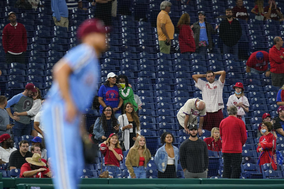 Fans reacts after Philadelphia Phillies pitcher Ian Kennedy, left, gave up a two-run home run to Colorado Rockies' Ryan McMahon during the ninth inning of a baseball game, Thursday, Sept. 9, 2021, in Philadelphia. (AP Photo/Matt Slocum)