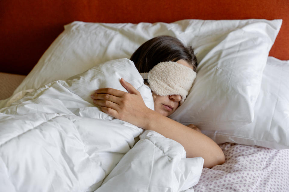 a woman sleeping with a sleep mask on her head