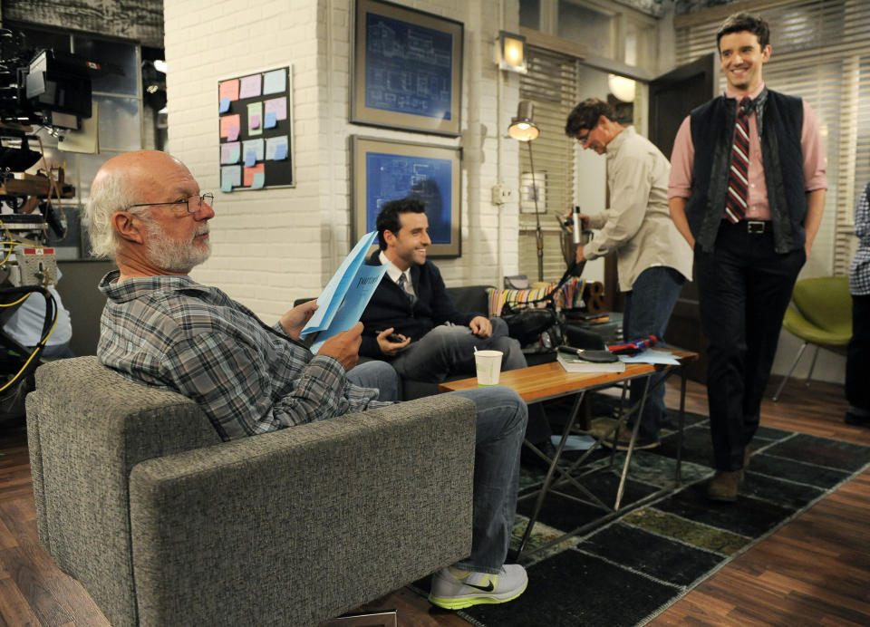 James Burrows, left, director of the television series "Partners," goes over a scene with cast members David Krumholtz, second from left, and Michael Urie, right, on Wednesday, Sept. 19, 2012, at Warner Bros. Studios in Burbank, Calif. Burrows isn't a household name. But behind the scenes Burrows reigns as a comedy giant. He's a director whose brand of funny business has helped shape TV comedy season after season. (Photo by Chris Pizzello/Invision/AP)