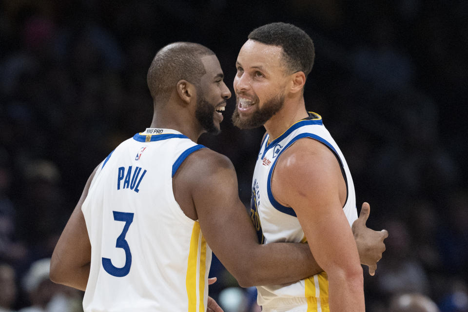 Golden State Warriors guard Stephen Curry (30) and teammate Chris Paul (3) laugh during the second half of an NBA basketball game in Washington, Tuesday, Feb. 27, 2024. (AP Photo/Manuel Balce Ceneta)