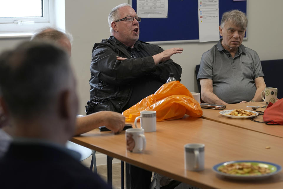 Barrie Stradling, a la izquierda, habla durante el almuerzo semanal de unos 20 jubilados en el centro comunitario Tredegar de Bow, el jueves 16 de mayo de 2024, en el este de Londres. (AP Foto/Alastair Grant)