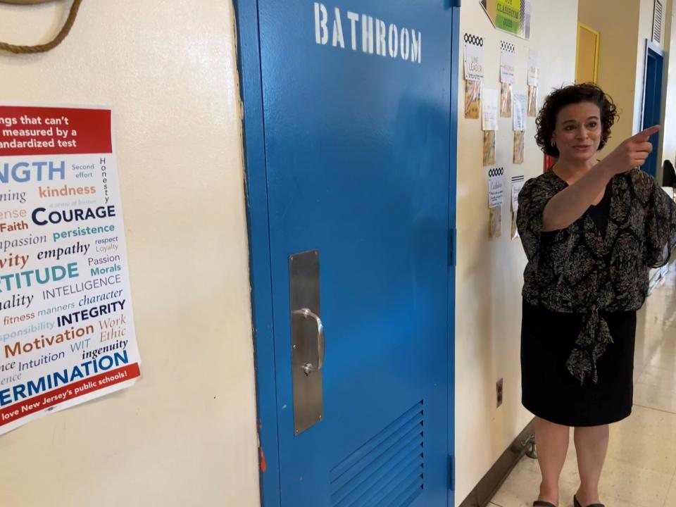 Fifth grade teacher Louise Hanania shows the small bathroom that close to thirty students pack into during emergency drills at Paterson's Roberto Clemente elementary school.