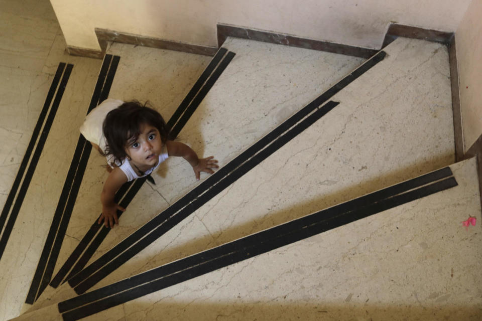 <p>A child crawls on the steps of an abandoned hospital wing, which is used as a make shift shelter for around 150 Syrian refugees, in Athens, Aug. 31, 2016. Over 59,000 people remain stranded in the country, most in army-built camps on the mainland and about 7,800 refugees are receiving hotel vouchers or live in vacant apartments. (Photo: Thanassis Stavrakis/AP)</p>