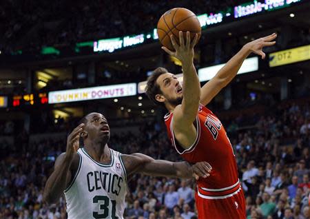 Chicago Bulls guard Marco Belinelli (R) of Italy scores a basket past Boston Celtics forward Brandon Bass in the second half of their NBA basketball game in Boston, Massachusetts February 13, 2013. REUTERS/Brian Snyder