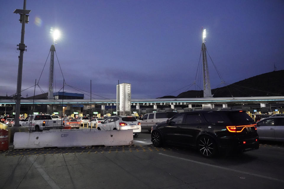 Cars pass barriers at the entrance to the San Ysidro Port of Entry Wednesday, March 2, 2022, seen from Tijuana, Mexico. More than 8,600 Russians have sought refuge in the U.S. on the Mexican border in recent months. To claim asylum in the U.S., they reach a tiny piece of U.S. soil before inspection booths. They must outsmart U.S. officers who try to block their path. (AP Photo/Gregory Bull)