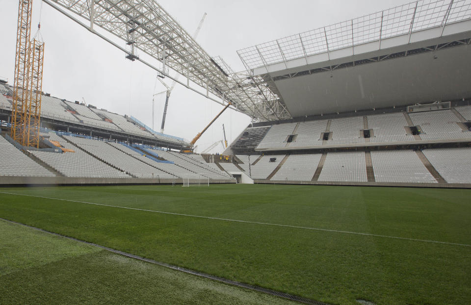 Men work at the still unfinished Itaquerao stadium in Sao Paulo, Brazil, Tuesday, April 15, 2014. The stadium that will host the World Cup opener match between Brazil and Croatia on June 12, will hold nearly 70,000 people in the opener, but after the World Cup its capacity will be reduced to about 45,000. (AP Photo/Andre Penner)