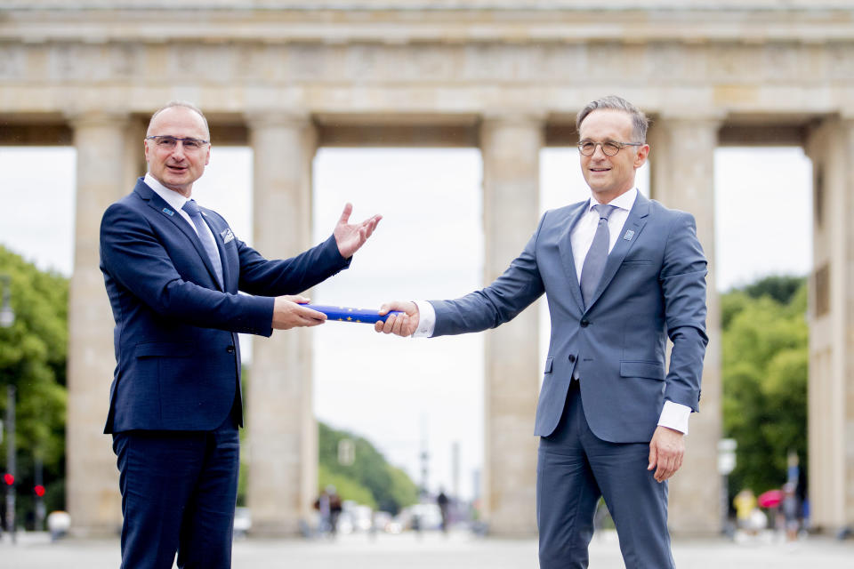 01 July 2020, Berlin: Gordan Grlic Radman (l), Foreign Minister of the Republic of Croatia, symbolically hands over the baton to Heiko Maas (SPD), Foreign Minister, in front of the Brandenburg Gate on the occasion of Germany taking over the EU Council Presidency from Croatia. From 1 July, Germany will assume the EU Council Presidency under the motto "Together. Making Europe strong again". The logo features a Möbius strip - a symbol of unity and solidarity. Photo: Christoph Soeder/dpa (Photo by Christoph Soeder/picture alliance via Getty Images)