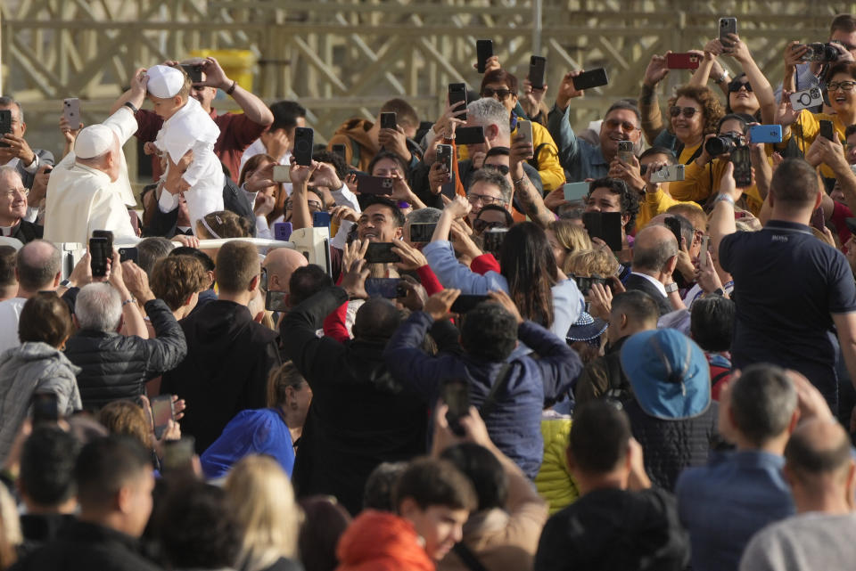 Pope Francis blesses a child wearing a pontiff costume as he tours St. Peter's Square on the popemobile during the weekly general audience at the Vatican, Wednesday, Nov. 15, 2023. (AP Photo/Gregorio Borgia)