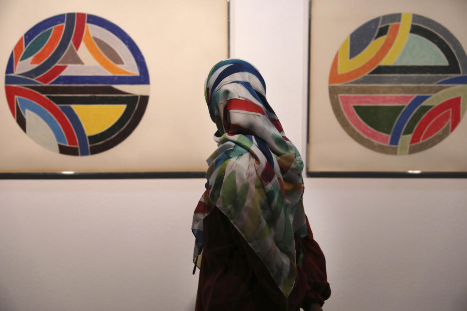 FILE - A visitor looks at works by U.S. artist Frank Stella, Sinjerli Variations No. 1-5- 1977, while visiting a 19th and 20th-century American and European minimalist and conceptual masterpieces show at the Tehran Museum of Contemporary Art in Tehran, Iran, Aug. 2, 2022. Stella, a painter, sculptor and printmaker whose constantly evolving works are hailed as landmarks of the minimalist and post-painterly abstraction art movements, died Saturday, May 4, 2024, at his home in Manhattan. He was 87. (AP Photo/Vahid Salemi, File)