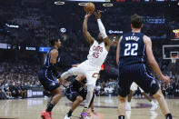 Cleveland Cavaliers guard Donovan Mitchell (45) shoots against Orlando Magic guard Gary Harris, left, and forward Franz Wagner (22) during the first half of Game 2 of an NBA basketball first-round playoff series, Monday, April 22, 2024, in Cleveland. (AP Photo/Ron Schwane)