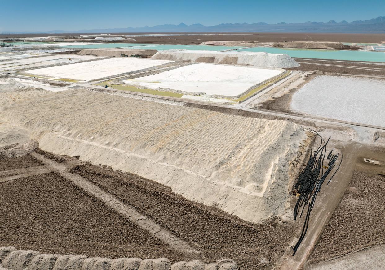 mounds of salt byproduct from lithium production stand next to lithium evaporation ponds at a mine in the Atacama Desert on Aug. 24 in Salar de Atacama, Chile.