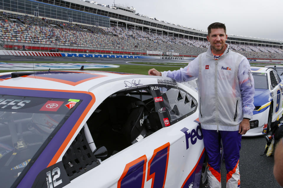 Denny Hamlin stands beside his car before the start of a NASCAR Cup Series auto race at Charlotte Motor Speedway in Concord, N.C., Sunday, Oct. 11, 2020. (AP Photo/Nell Redmond)