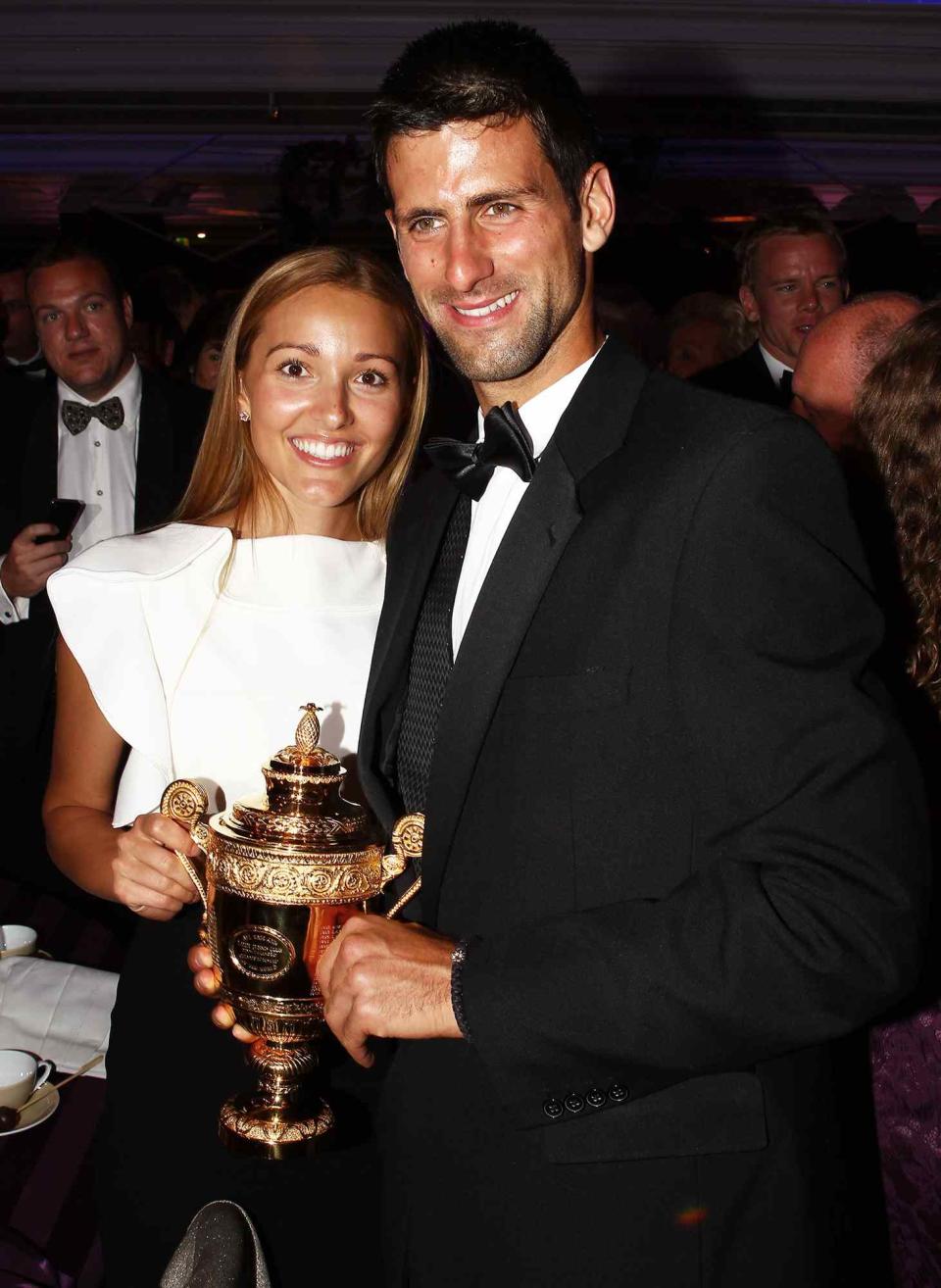 Novak Djokovic of Serbia poses with the mens replica trophy with his girlfriend Jelena Ristic at the Wimbledon Championships 2011 Winners Ball at the InterContinental Park Lane Hotel on July 3, 2011 in London, England