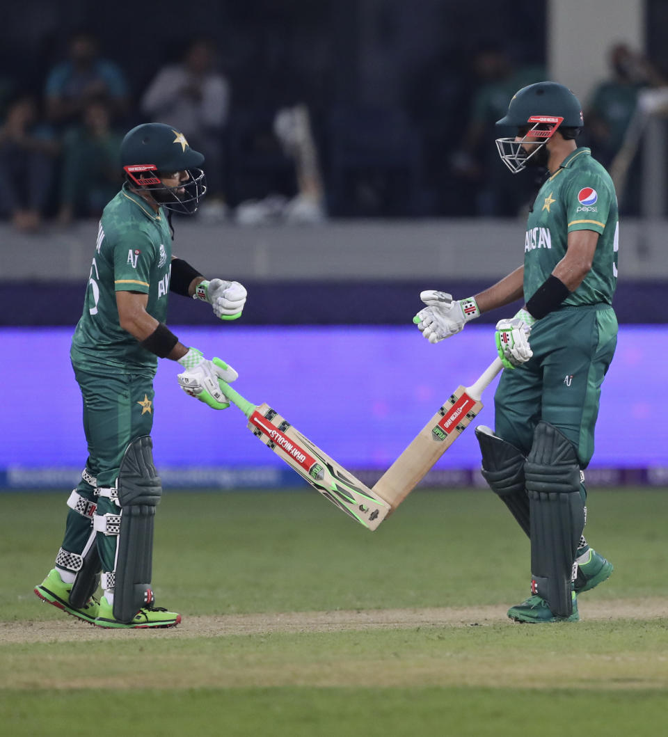 Pakistan's cricket captain Babar Azam, right, and Mohammad Rizwan celebrate scoring runs during the Cricket Twenty20 World Cup match between India and Pakistan in Dubai, UAE, Sunday, Oct. 24, 2021. (AP Photo/Aijaz Rahi)